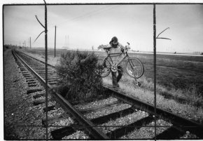 Alan Selfridge together with dog Maggie ride the abandoned SP rails near the Dunbarton Bridge - East Palo Alto. Selfridge has to derail their bicycle and carry it around the obstruction on the abandoned tracks. The outrigger keeps the bicycle balanced. The roller device guides and keeps the bike regarding the track. (picture by Michael Maloney / The Chronicle)