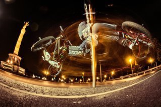 BMX freestyler Tim Knoll spins around a pole in Berlin, Germany on July 15, 2015
